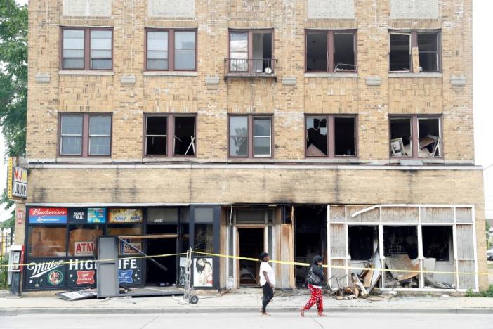 A burned down liquor store is seen after disturbances following the police shooting of a man in Milwaukee, Wisconsin